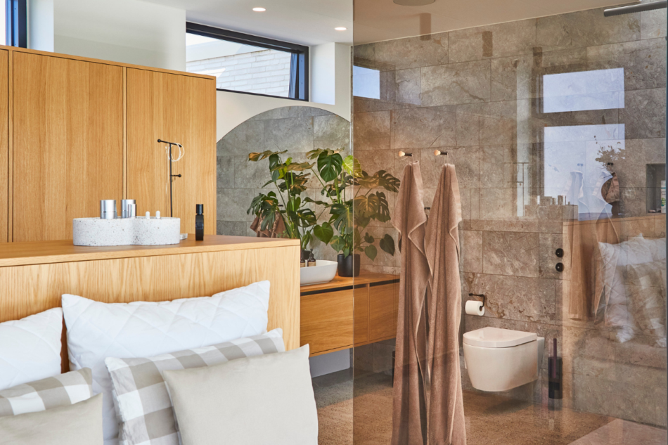 Badeværelse med træelementer og glasafskærmet bruseniche